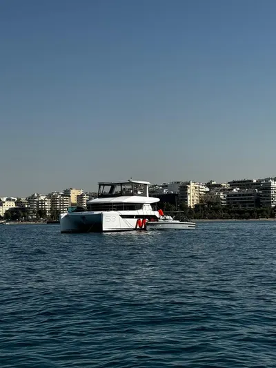 Plan C Yacht Photos Pics 2024 Leopard 53 Powercat on calm water with cityscape background.