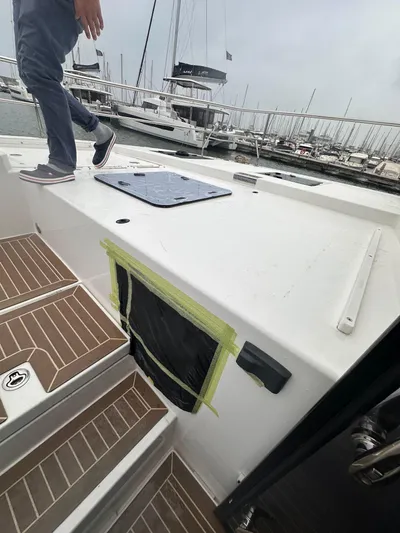 Plan C Yacht Photos Pics 2024 Leopard 53 Powercat yacht deck with person walking, docked at marina.