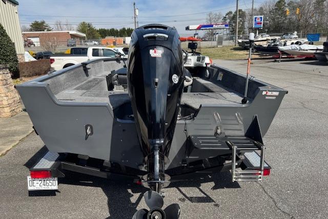 2018 Tracker Pro Guide V-175 SC boat, rear view with outboard motor, parked outdoors.