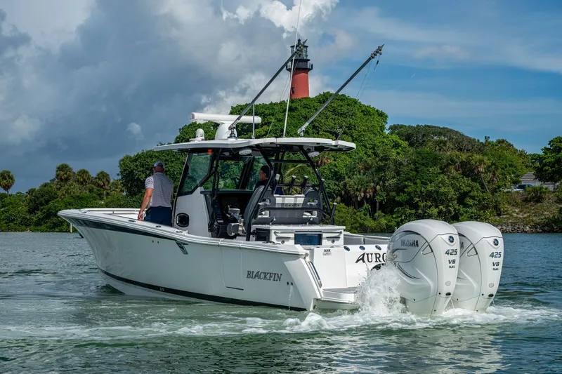 Aurora Yacht Photos Pics 2019 Blackfin 332 boat cruising near lush greenery and lighthouse, powered by twin Yamaha 425 engines.