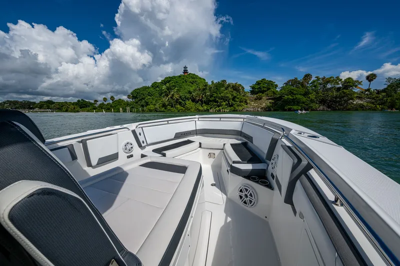 Aurora Yacht Photos Pics 2019 Blackfin 332 boat interior with seating, on a scenic waterway under a blue sky.