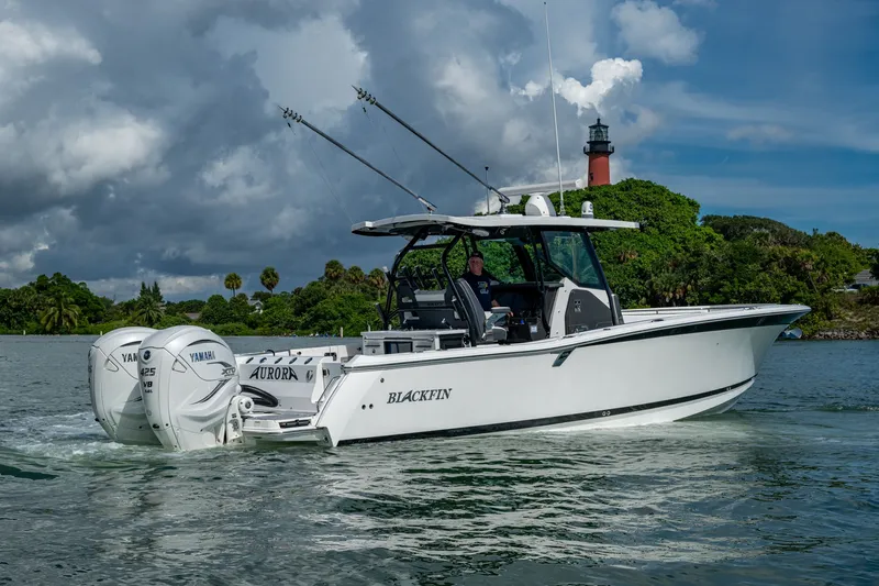 Aurora Yacht Photos Pics 2019 Blackfin 332 boat with twin Yamaha engines on water, lighthouse in background.