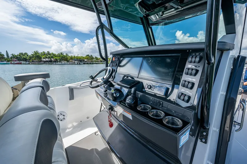 Aurora Yacht Photos Pics 2019 Blackfin 332 boat cockpit with modern controls and scenic waterfront view.