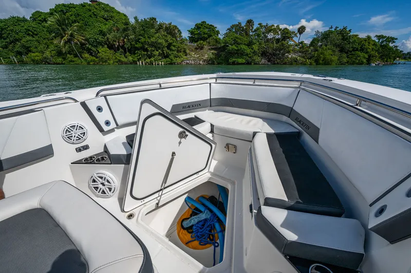 Aurora Yacht Photos Pics 2019 Blackfin 332 boat interior with open storage compartment, surrounded by lush greenery.