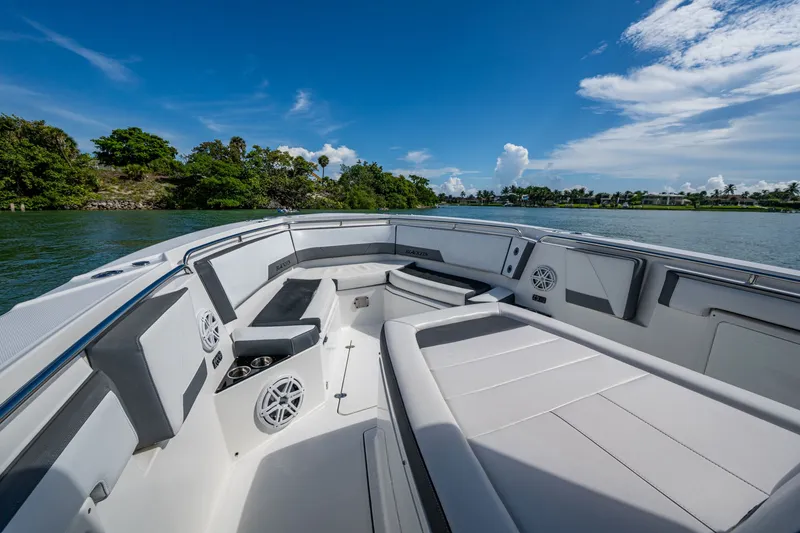 Aurora Yacht Photos Pics 2019 Blackfin 332 boat interior with seating, speakers, and cup holders on a sunny day.
