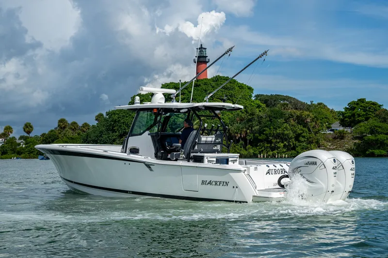 Aurora Yacht Photos Pics 2019 Blackfin 332 boat cruising near a lighthouse, powered by twin Yamaha engines.