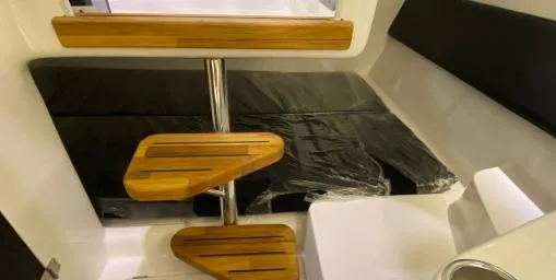 Ready For Immediate Delivery Yacht Photos Pics Interior of 2025 Hanover 305 Outboard, featuring wooden steps and black seating.