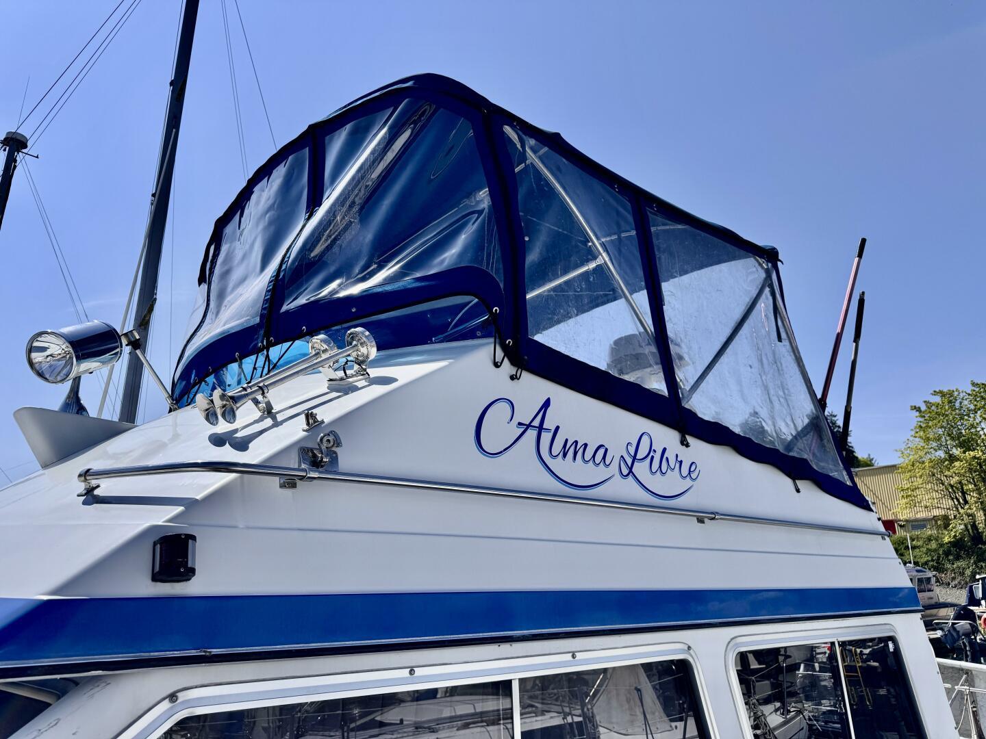 1985 Commander 30 boat with blue canopy and "Alma Libre" text on the side.