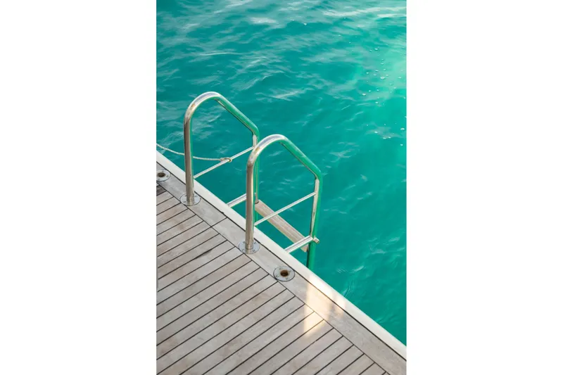 Exit Yacht Photos Pics Stainless steel ladder on Azimut 75 yacht, 2008, leading into turquoise water.
