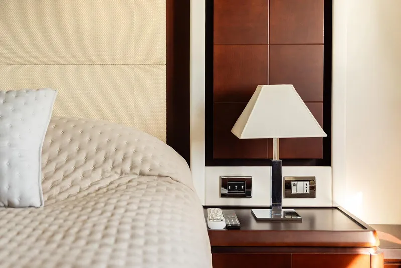 Exit Yacht Photos Pics Luxurious Azimut 75 yacht bedroom interior, featuring elegant bedding and a stylish bedside lamp.