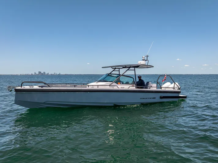  Yacht Photos Pics 2022 Axopar 28 T-Top Brabus boat cruising on open water under clear blue sky.