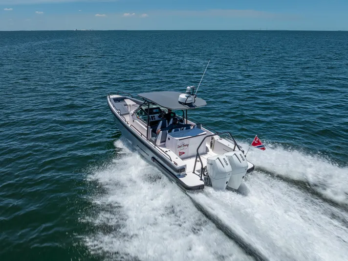  Yacht Photos Pics 2022 Axopar 28 T-Top Brabus cruising on open water, rear view.