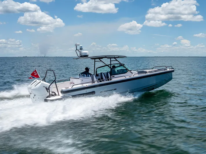  Yacht Photos Pics 2022 Axopar 28 T-Top Brabus cruising on open water under a clear blue sky.