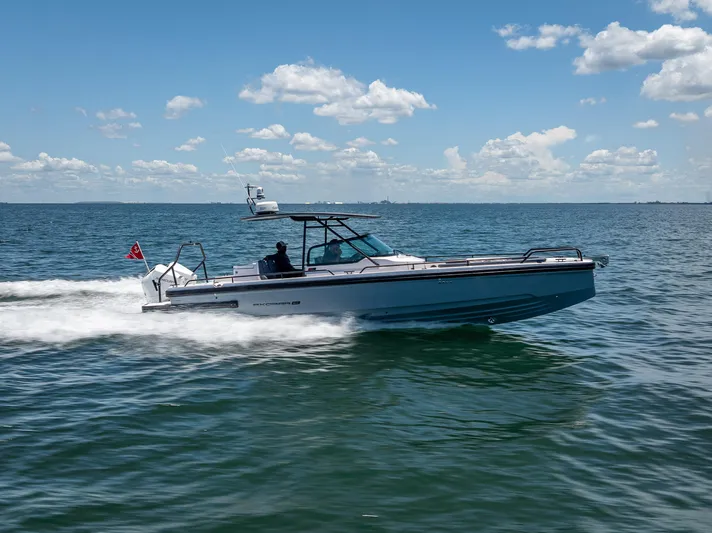  Yacht Photos Pics 2022 Axopar 28 T-Top Brabus cruising on open water under a clear blue sky.