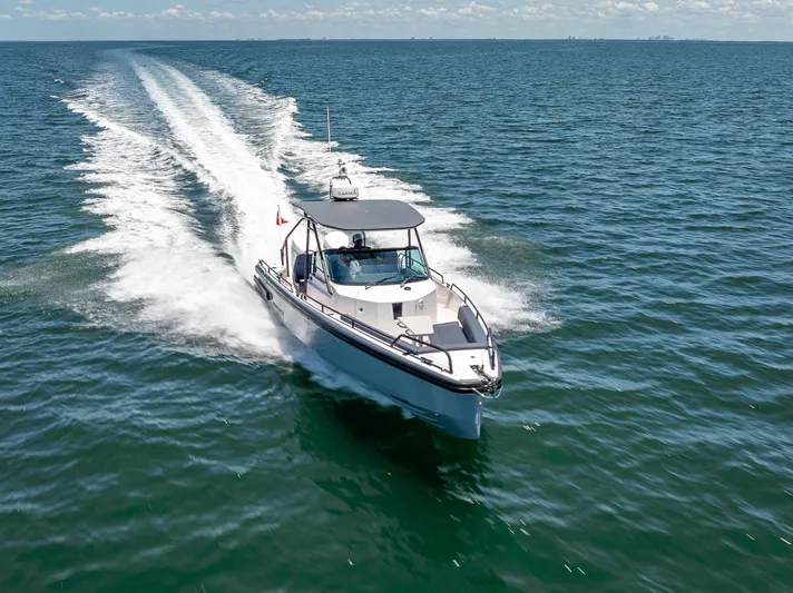  Yacht Photos Pics 2022 Axopar 28 T-Top Brabus cruising on open water, leaving a wake behind.