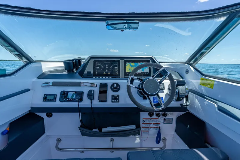  Yacht Photos Pics 2022 Axopar 28 T-Top Brabus boat dashboard with steering wheel and navigation screens.