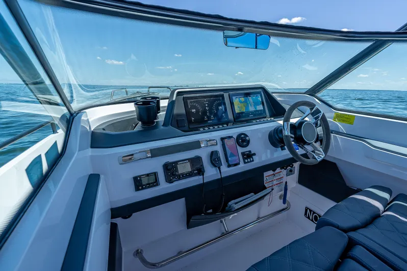  Yacht Photos Pics 2022 Axopar 28 T-Top Brabus helm with modern navigation equipment on open water.