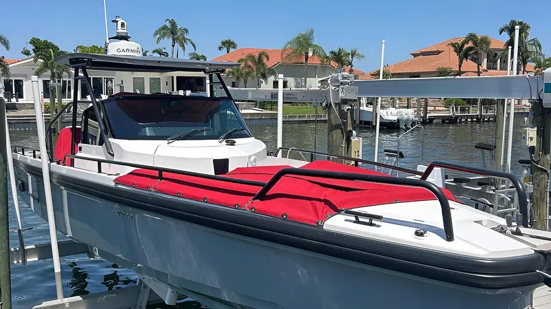  Yacht Photos Pics 2022 Axopar 28TT Brabus boat with red seating, docked in a sunny marina.