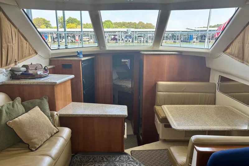  Yacht Photos Pics Interior of 2001 Carver 356 Motor Yacht with seating, table, and windows overlooking marina.