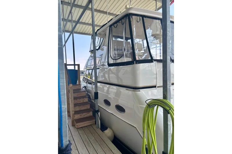  Yacht Photos Pics 2001 Carver 356 Motor Yacht docked under a covered marina with wooden steps.