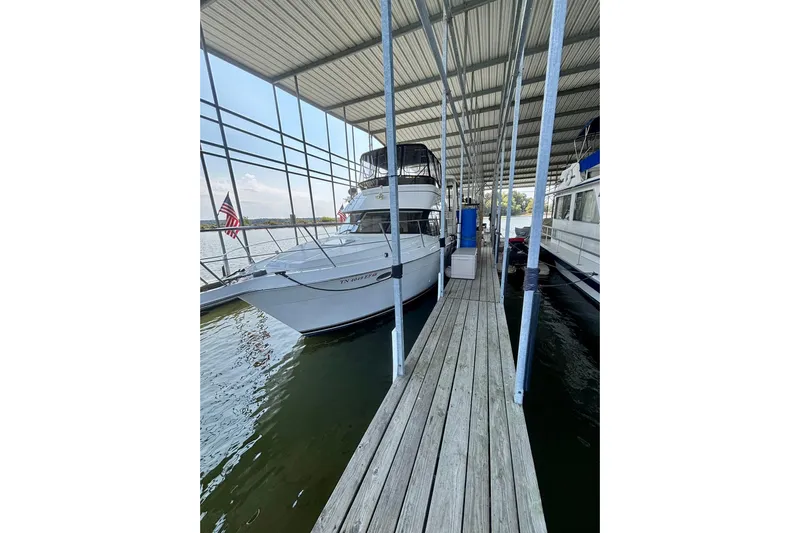  Yacht Photos Pics 2001 Carver 356 Motor Yacht docked under covered marina with American flag.
