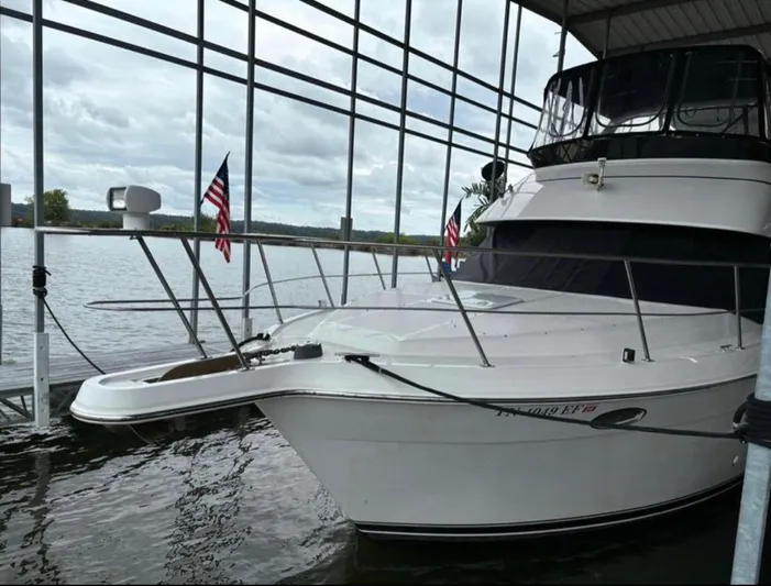  Yacht Photos Pics 2001 Carver 356 Motor Yacht docked with American flags, under a covered marina.