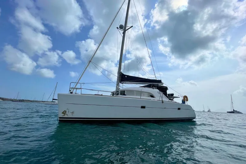 Plan B Yacht Photos Pics 2002 Lagoon 380 catamaran sailing on calm waters under a partly cloudy sky.