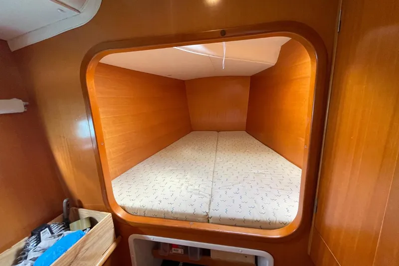 Plan B Yacht Photos Pics Cozy cabin interior of 2002 Lagoon 380 catamaran with wooden finish and comfortable bedding.