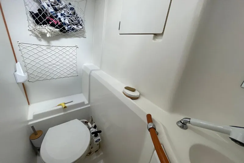 Plan B Yacht Photos Pics Compact bathroom in a 2002 Lagoon 380 catamaran with toilet and storage nets.