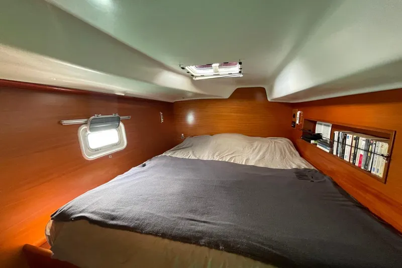 Plan B Yacht Photos Pics Cozy cabin interior of 2002 Lagoon 380 catamaran with bed and bookshelf.