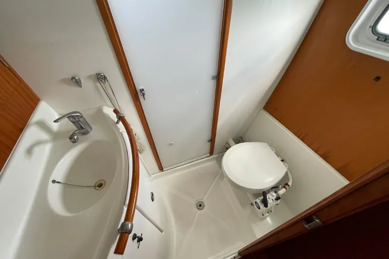 Plan B Yacht Photos Pics Compact bathroom in 2002 Lagoon 380 catamaran with sink, toilet, and shower area.
