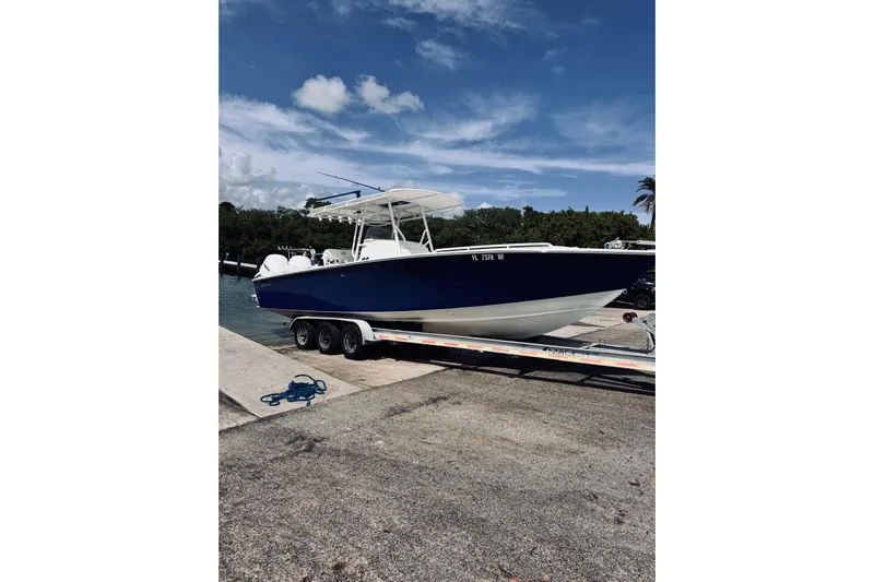  Yacht Photos Pics 2005 Jupiter 31 boat on trailer at dock, under clear blue sky.