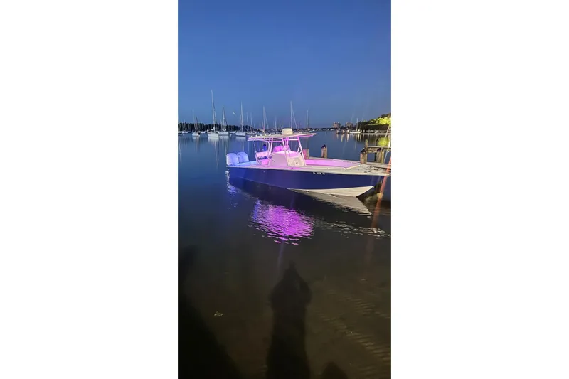  Yacht Photos Pics 2005 Jupiter 31 boat with pink lights docked at night, reflecting on calm water.