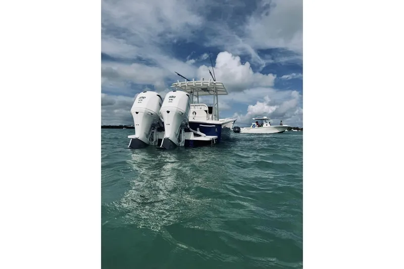 Yacht Photos Pics 2005 Jupiter 31 boat with twin outboard engines on open water under cloudy sky.