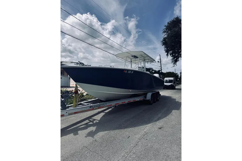  Yacht Photos Pics 2005 Jupiter 31 boat on trailer under cloudy sky.
