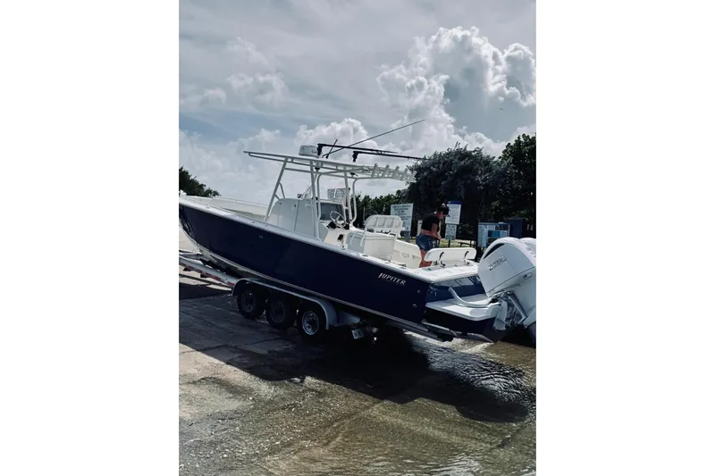  Yacht Photos Pics 2005 Jupiter 31 boat on trailer at boat ramp under cloudy sky.