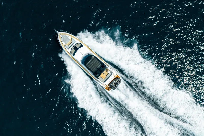 Mahalo Yacht Photos Pics Aerial view of 2018 Sunseeker Manhattan 66 yacht cruising on open water.