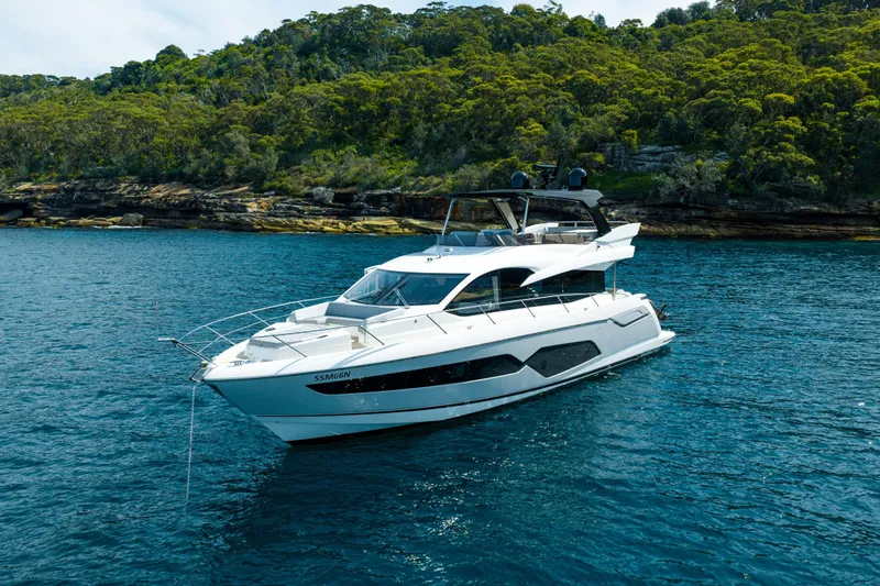 Mahalo Yacht Photos Pics 2018 Sunseeker Manhattan 66 yacht on serene water near lush green shoreline.