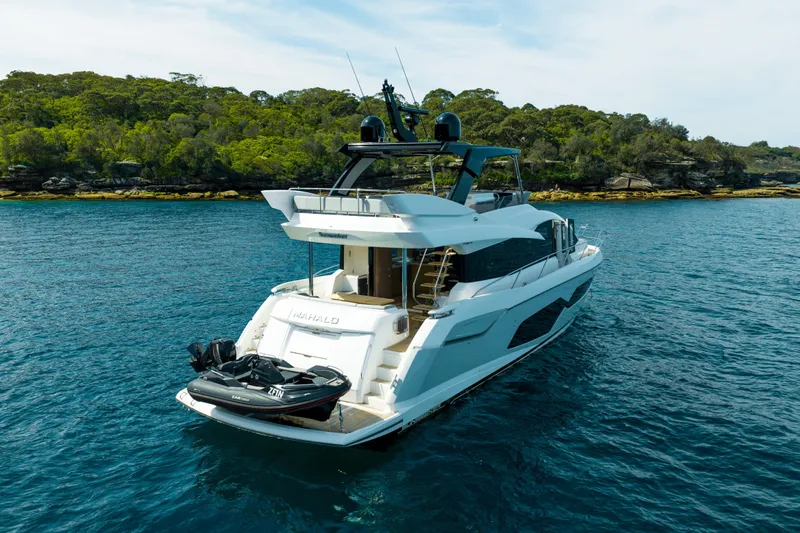 Mahalo Yacht Photos Pics 2018 Sunseeker Manhattan 66 yacht on serene water near lush green shoreline.