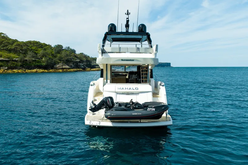Mahalo Yacht Photos Pics 2018 Sunseeker Manhattan 66 yacht on serene blue waters, rear view with tender.