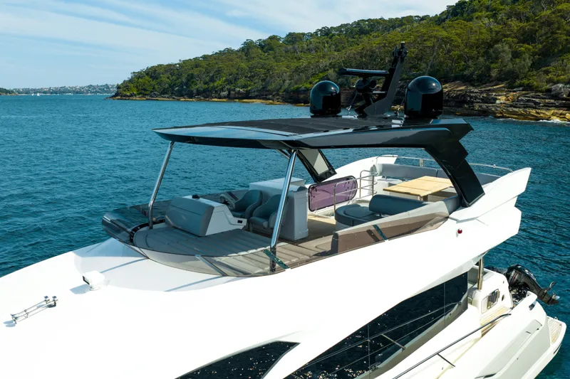 Mahalo Yacht Photos Pics 2018 Sunseeker Manhattan 66 yacht on serene blue waters near lush coastline.