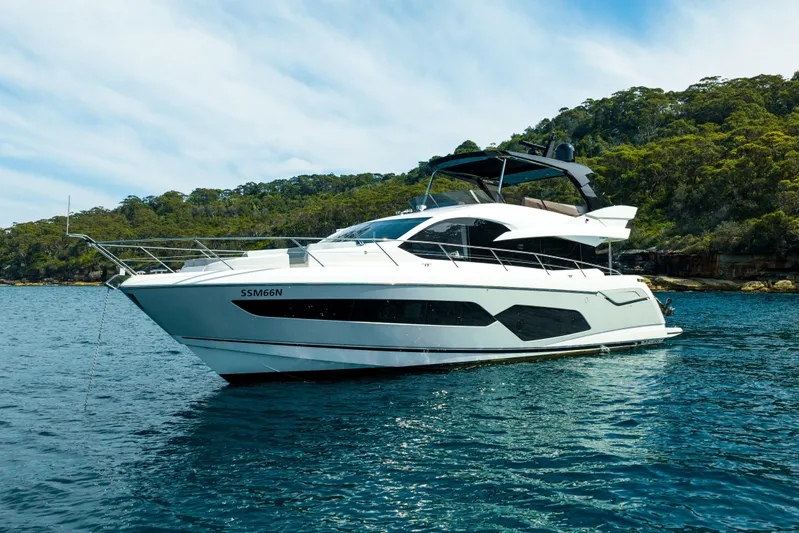 Mahalo Yacht Photos Pics 2018 Sunseeker Manhattan 66 yacht on serene water with lush green backdrop.