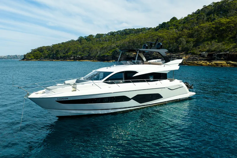 Mahalo Yacht Photos Pics 2018 Sunseeker Manhattan 66 yacht on serene water with lush green shoreline.