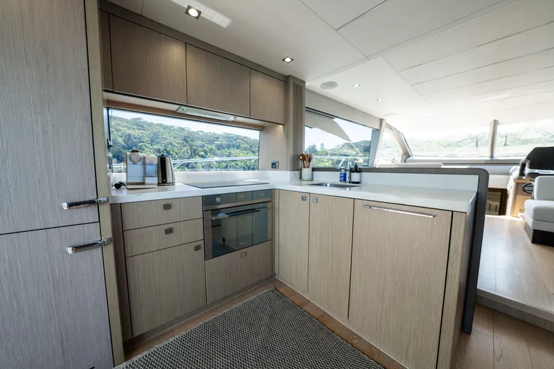 Mahalo Yacht Photos Pics Modern kitchen interior on 2018 Sunseeker Manhattan 66 yacht, featuring sleek cabinetry and appliances.