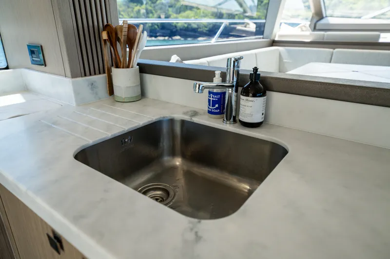 Mahalo Yacht Photos Pics Modern kitchen sink on 2018 Sunseeker Manhattan 66 yacht with elegant countertop accessories.