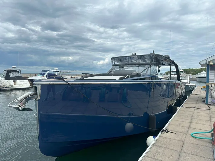 Imonna Yacht Photos Pics 2024 Cranchi A46 yacht docked at marina under cloudy sky.