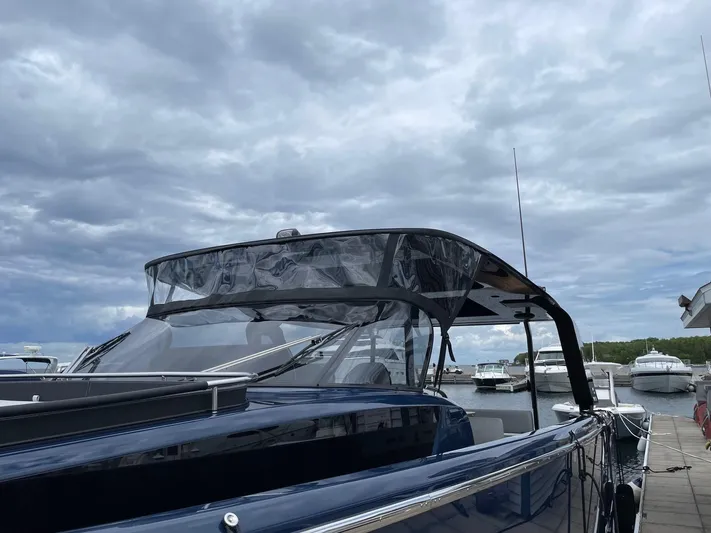 Imonna Yacht Photos Pics 2024 Cranchi A46 yacht docked under cloudy skies.