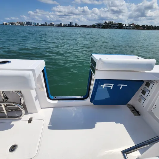  Yacht Photos Pics 2022 Southport 30 FE boat deck with open side door, overlooking calm water and distant skyline.