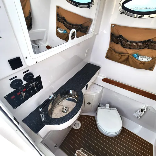  Yacht Photos Pics 2022 Southport 30 FE boat bathroom with sink, toilet, and storage compartments.