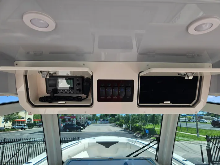  Yacht Photos Pics 2024 Sailfish 312CC boat console with electronic equipment and storage compartments.